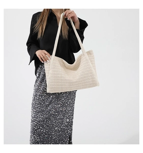 Close-up of beige woven tote bag showing detailed horizontal straw texture and straps