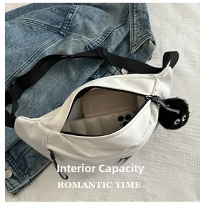 Detail view of white canvas waist bag internal capacity with essentials and plush charm