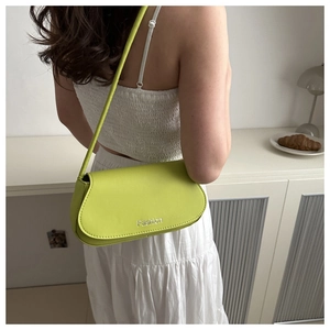 Back view of model wearing a lime green saddle bag with silver Fashion logo detail