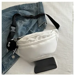 Close-up of white crossbody bag with FANYISSA text, black strap, and fuzzy ball charm