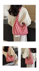 Detail of red striped canvas tote bag showing the side pocket and thick durable texture