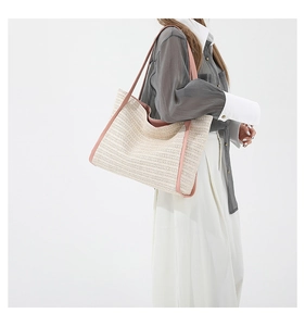 Detail of hand-woven beige straw tote with pink leather straps and soft texture