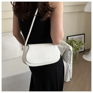 Detailed view of a white leather saddle bag showing the Fashion logo and shoulder strap