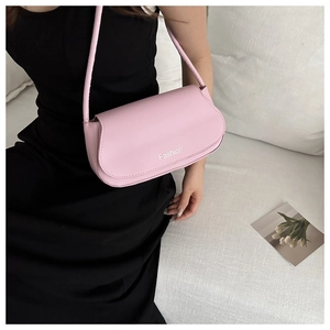 Detailed close-up of a pink synthetic leather baguette bag with Fashion logo print