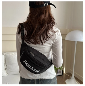 Detail of adjustable strap and buckle on a black crossbody bag with logo printing
