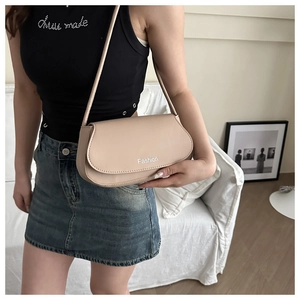 Chic beige saddle shoulder bag for women with 'Fashion' print in a modern home setting