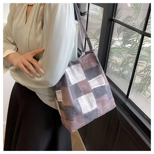 Detail of vintage patchwork canvas shoulder bag showing multi-color fabric texture and strap