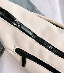 Close-up of smooth black zippers and durable canvas fabric on the minimalist crossbody bag