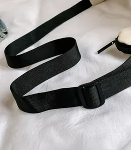 Detail of adjustable black nylon shoulder strap and smooth zipper on a casual crossbody bag