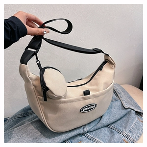 Detail view of beige nylon crescent bag with adjustable wide strap and mini round pouch