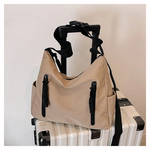 Détail d'un sac cabas fonctionnel kaki avec doubles zips noirs sur une valise