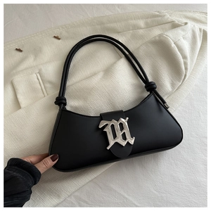 Detail of black underarm bag featuring silver Gothic M buckle and knotted shoulder strap