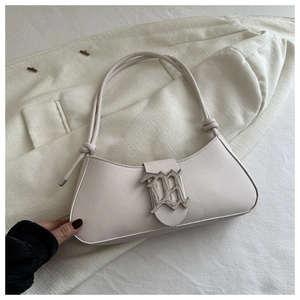 Close-up of cream leather hobo bag with a silver gothic logo on white blazer