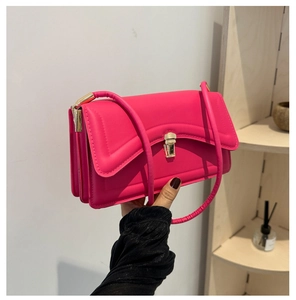Detail view of pink flap bag showing three-layer accordion structure and gold buckle
