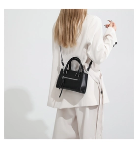 Détail d'un petit sac bandoulière en cuir noir avec fermeture éclair argentée chic