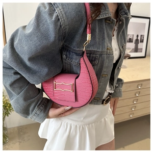 Dettaglio borsa sottobraccio rosa effetto coccodrillo con fibbia metallica dorata chic