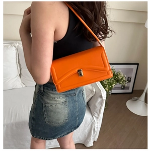 Fashionable bright orange leather shoulder bag with gold clasp and V-shaped stitching