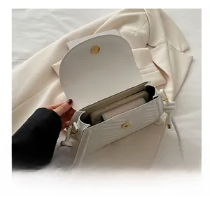 Interior capacity of white quilted saddle bag showing phone and power bank space