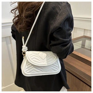 Detail of white quilted heart pattern and wave texture on casual chic shoulder bag