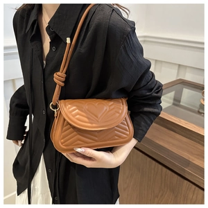 Detail of camel quilted shoulder bag with heart stitching and knotted strap design