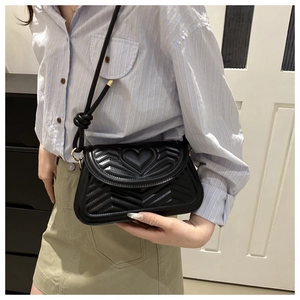 Black quilted crossbody bag with heart embossing and gold-tone hardware detail