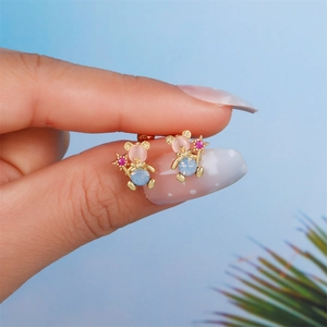 Close-up of golden bear stud earrings with colorful stones and star detail