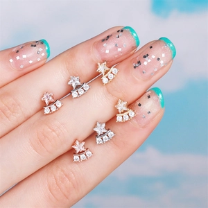 Star-shaped stud earring set in gold and silver finish shown on a soft cloud background