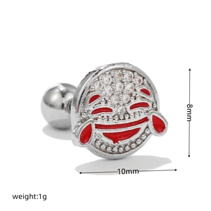 Macro detail of smiley emoji cartilage stud earring with cubic zirconia and red enamel
