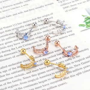 Macro detail of crescent moon ear studs with blue cat's eye stone and pavé zircon stones