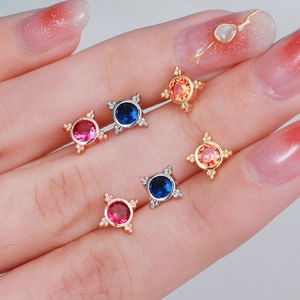 Macro shot of stainless steel flower ear studs with colorful zircon crystals on hands
