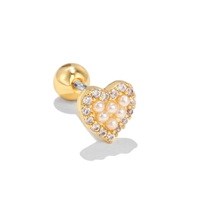 Detalle macro de un pendiente de corazón dorado con perlas y circonitas blancas