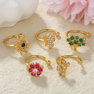 Detail of five gold ear cuffs featuring zircon butterfly, tree, and flower designs