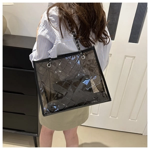 Détail du sac cabas en PVC transparent avec motif losanges noirs et bandoulière chaîne