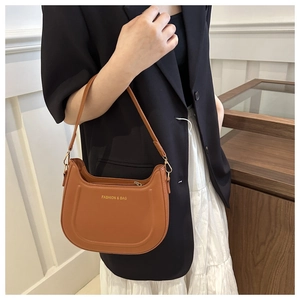 Dettaglio della borsa sottobraccio in pelle PU marrone con scritta dorata Fashion