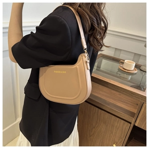 Borsa sottobraccio in pelle kaki stile francese indossata in un ambiente caffè
