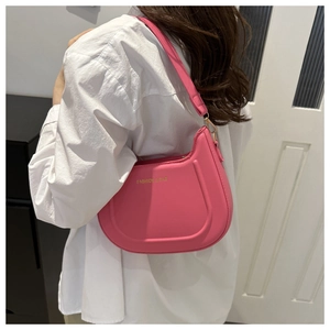 Borsa a spalla rosa acceso a mezza luna mostrata su una modella con camicia bianca