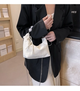 Detail of white PU shoulder bag with decorative clear beads and elegant bow tie accent