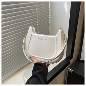 Dettaglio della borsa a spalla bianca a mezzaluna con logo dorato e fibbia in metallo