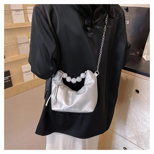 Silver crescent shoulder bag with chunky beaded handle and metal chain strap in modern style