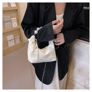 Detail of white PU leather bag with decorative ribbon bow and beaded top handle