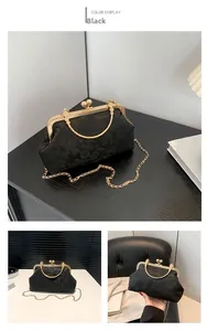 Gros plan sur le tissu jacquard floral noir et le fermoir vintage doré du sac à main