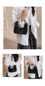 Detailed view of black crescent bag with amber bead handle and silver chain strap