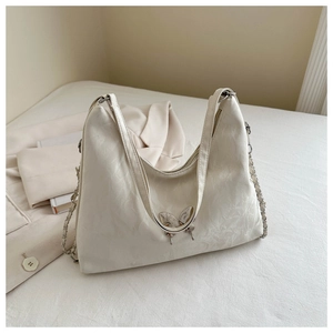 Détail du sac à bandoulière en cuir PU blanc cassé avec breloque papillon et bandoulière