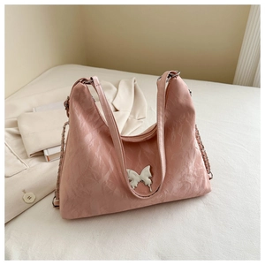 Close-up of pink pleated PU leather tote bag with silver butterfly buckle and chain strap