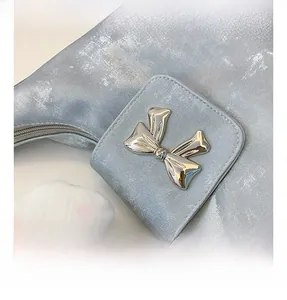 Detail shot of the silver metallic bucket bag with a stylish bow-shaped hardware buckle