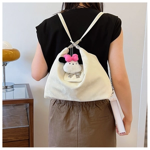 Detailed back view of a cream leather backpack with a cute plush charm and silver bow