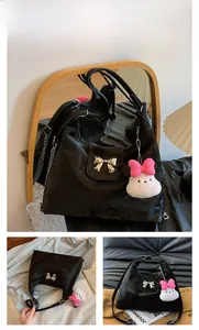 Detail showing black velvet texture bag with silver bow lock and plush rabbit charm