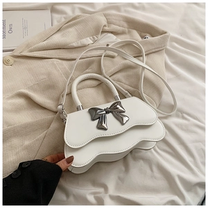 Détail du sac blanc à bords ondulés avec une boucle en métal argenté en forme de nœud