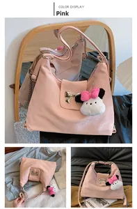 Detail of pink matte shoulder bag with silver bow and cute plush panda charm