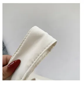 Détail de la bandoulière en toile blanc cassé avec coutures renforcées d'un cabas